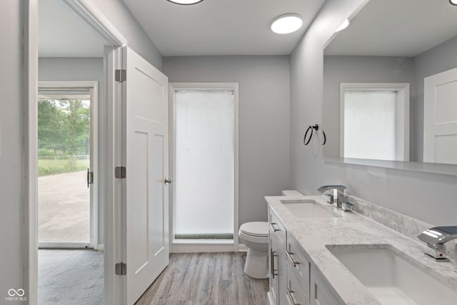 bathroom featuring double vanity, toilet, and wood finished floors | Image 21