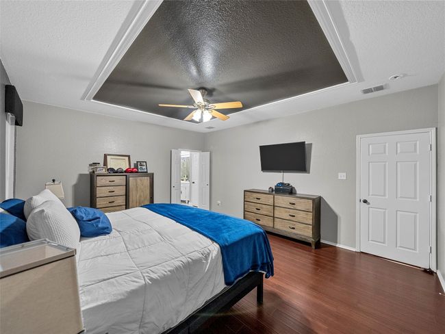 Bedroom with wood finished floors, a textured ceiling, and visible vents | Image 20