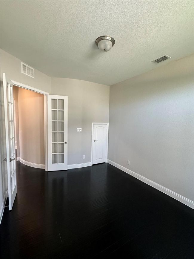 Unfurnished room with french doors, a textured ceiling, and dark wood finished floors | Image 25