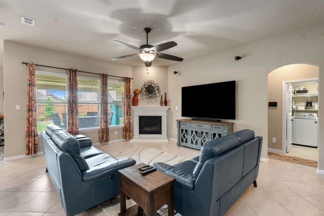 Living area featuring washer / dryer, arched walkways, ceiling fan, and light tile patterned flooring | Image 5