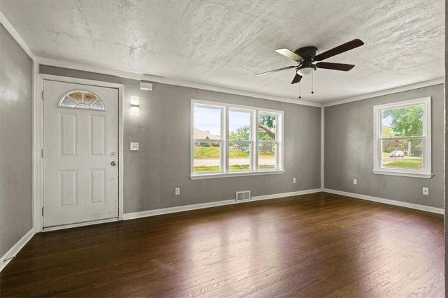 Entryway with wood finished floors, ceiling fan, and a textured ceiling | Image 5