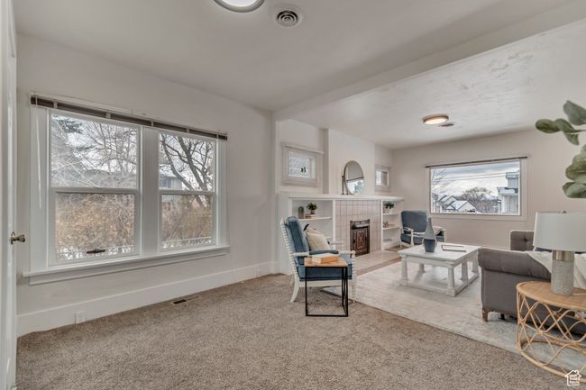 Living room with visible vents, a fireplace, baseboards, and carpet floors | Image 5