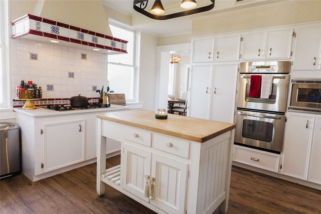 Kitchen featuring white cabinets, a center island, stainless steel appliances, decorative backsplash, and crown molding | Image 18