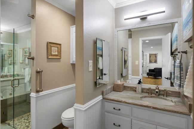 Bathroom featuring toilet, ornamental molding, a stall shower, and wainscoting | Image 18