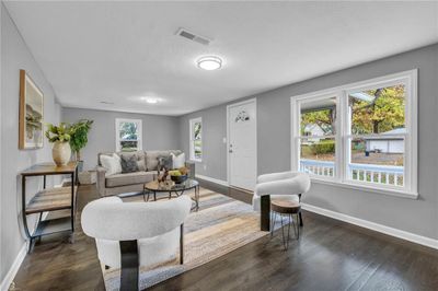 Living room featuring dark hardwood / wood-style floors and a healthy amount of sunlight | Image 1