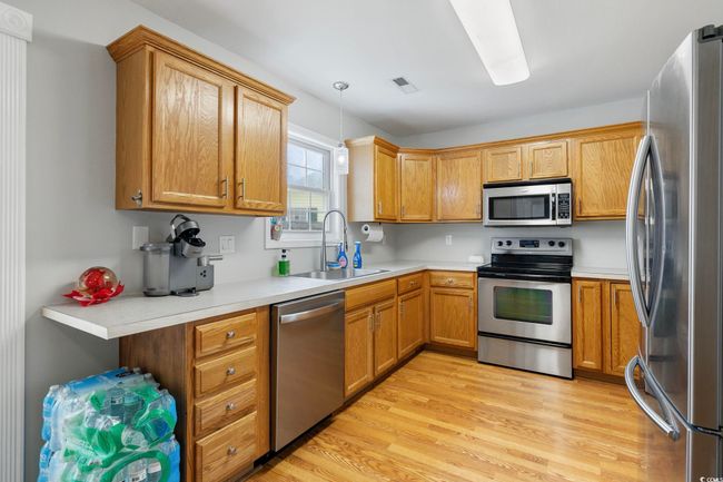 Kitchen featuring appliances with stainless steel finishes, a sink, light countertops, and light wood-style floors | Image 27