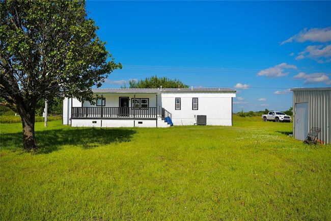 Rear view of property featuring a yard, central air condition unit, and a porch | Image 15