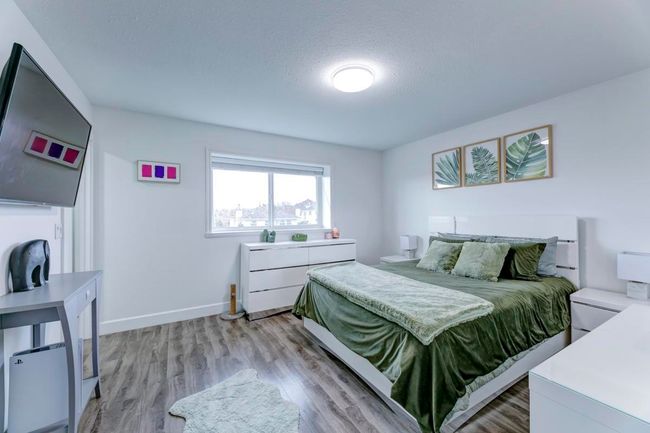 Bedroom featuring light wood-type flooring, baseboards, and a textured ceiling | Image 12