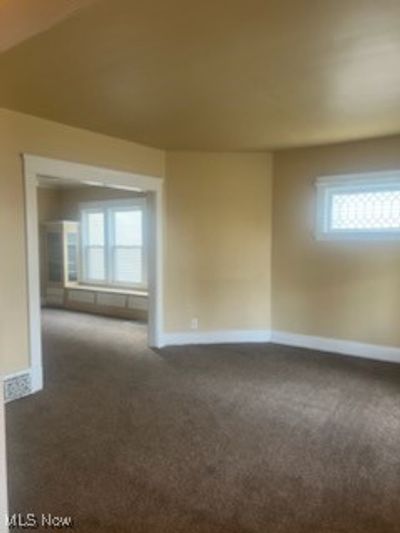 Unfurnished room with dark colored carpet | Image 1