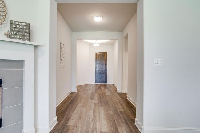 Hall featuring wood finished floors and baseboards | Image 6