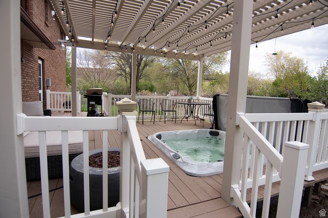 Wooden terrace featuring an outdoor hot tub, a pergola, and area for grilling | Image 33