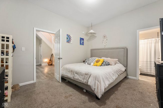 bedroom featuring carpet floors, baseboards, and ensuite bathroom | Image 14