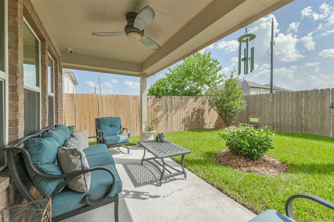 A charming patio area--featuring stylish metal chairs and table. The ceiling fan is great to cool off on a warm Summer's day. Ideal for enjoying your morning coffee or relaxing after a long day's work. | Image 34