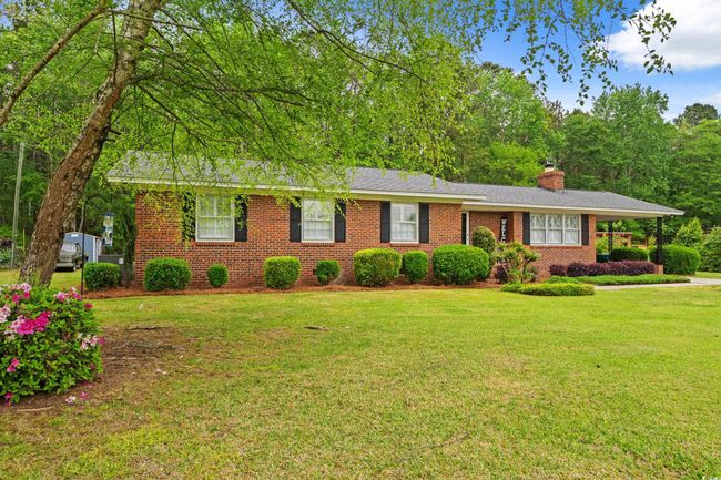 Ranch-style house with a chimney, brick siding, and a front yard | Image 25