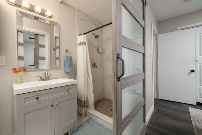 Full bathroom featuring a stall shower, wood finished floors, and vanity | Image 27