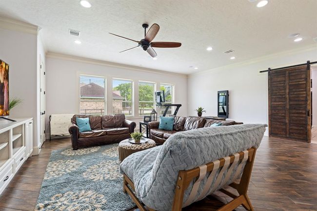 Four cased windows overlook the home’s large side-yard and provide welcoming natural light. This space can house a pool table, comfy couches, toys, or even workout equipment. This spacious room is ready to service you however you need. | Image 32