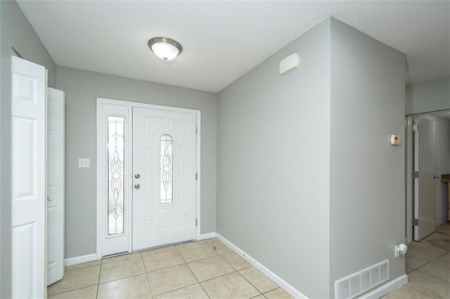 Foyer entrance featuring light tile patterned floors, visible vents, and baseboards | Image 6
