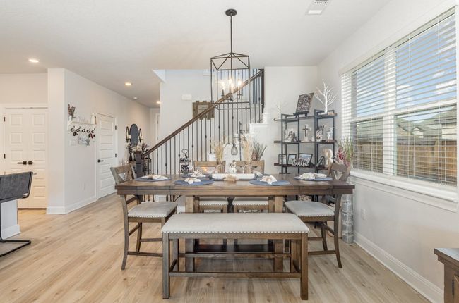 Dining space with stairway, light wood finished floors, baseboards, a chandelier, and recessed lighting | Image 5