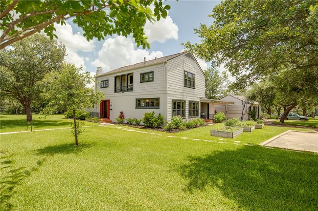 View of front of house featuring a chimney, a front lawn, a garden, and cooling unit | Image 49