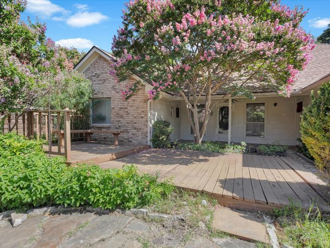 Large wooden deck allows for extra seating areas amidst the trees and greenery. | Image 35
