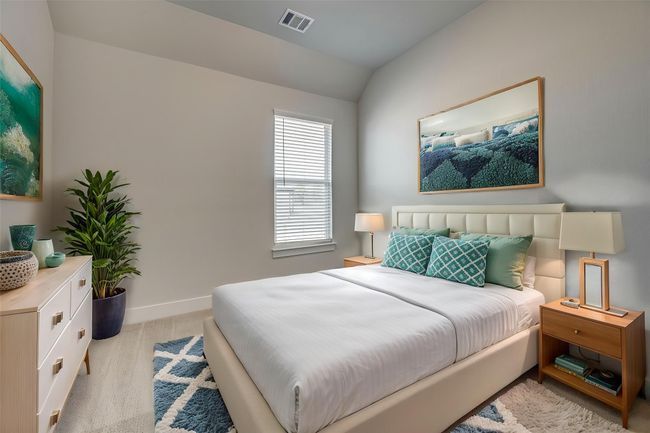 Bedroom featuring light colored carpet, baseboards, vaulted ceiling, and visible vents | Image 25