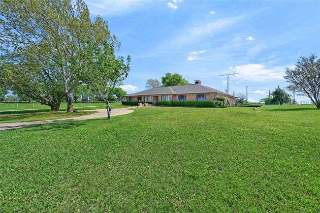 Ranch-style home featuring brick siding, a chimney, and a front lawn | Image 4