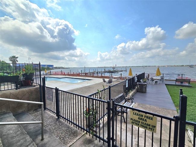 This waterfront property offers a stunning view with a pool, ample seating, and a dock. It's perfect for relaxing and enjoying outdoor activities by the water. | Image 31