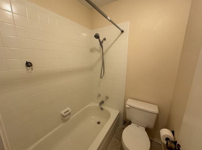 Bathroom with tiled shower / bath and toilet | Image 17