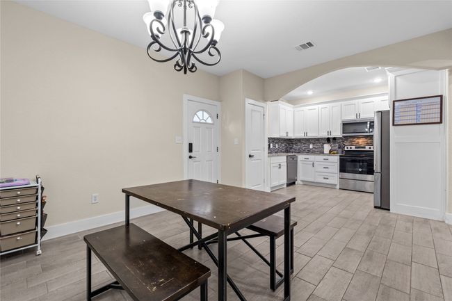 Dining room featuring arched walkways, light wood-style floors, and a chandelier | Image 19