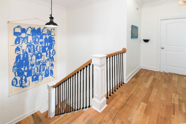 Hallway with ornamental molding, light wood-style flooring, an upstairs landing, and baseboards | Image 13