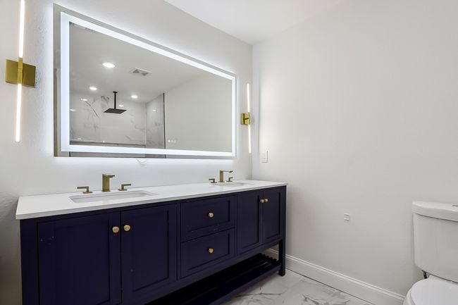 Full bath featuring marble finish floor, baseboards, a sink, and toilet | Image 17