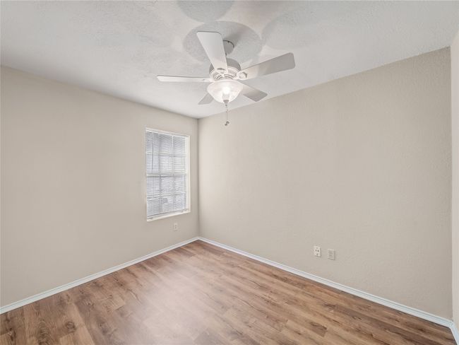 Spare room featuring wood finished floors, baseboards, and ceiling fan | Image 17