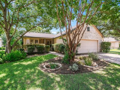 Lovely stucco and stone home with mature trees. The home has a covered front porch to enjoy the view and wildlife. | Image 1