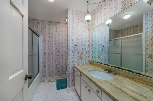 Bathroom with vanity, shower / bath combination with glass door, a textured ceiling, and tile patterned flooring | Image 26