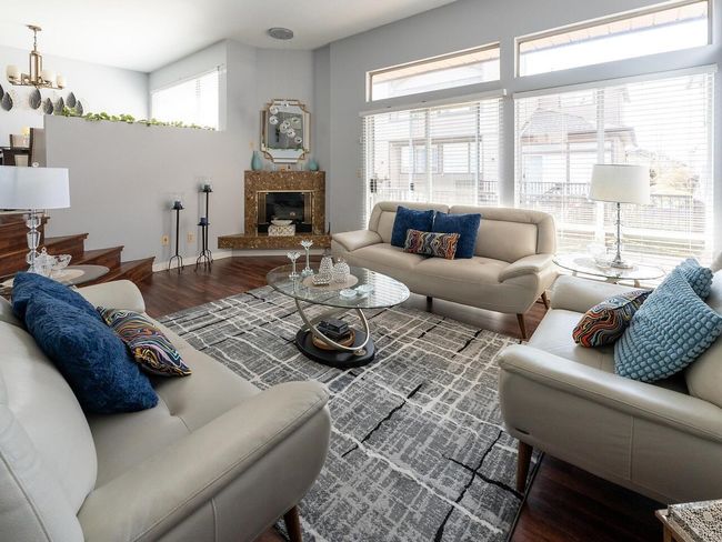 Living area with baseboards, wood finished floors, and a high end fireplace | Image 6