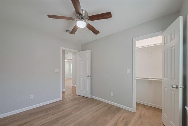 This secondary bedroom includes a full entry closet and ceiling fan, offering comfort and utility for guests or additional household members. | Image 20