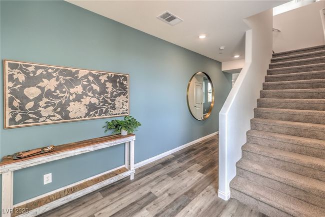 Stairway with wood finished floors, baseboards, and recessed lighting. Photo is representational only; actual home finishes may vary. | Image 17