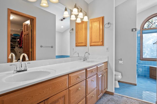 The full private owner’s bathroom has tile flooring, a Jacuzzi tub, separate shower, and a dual sink vanity. There is ample cabinet space for all your bathroom essentials. | Image 20