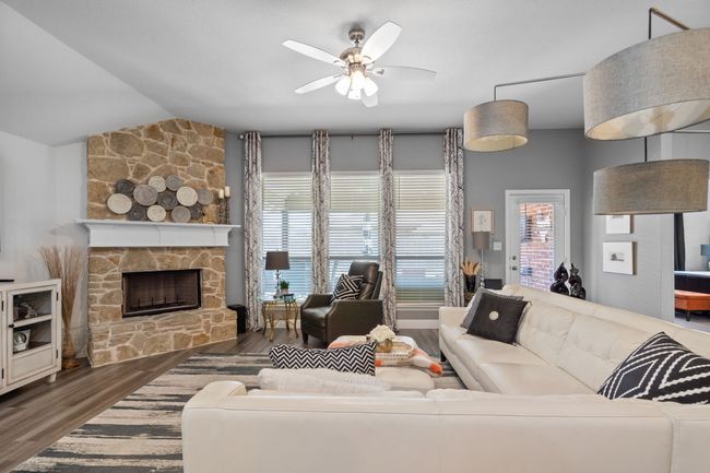 Cozy fireplace with a stone surround serves as the rooms focal point! | Image 14