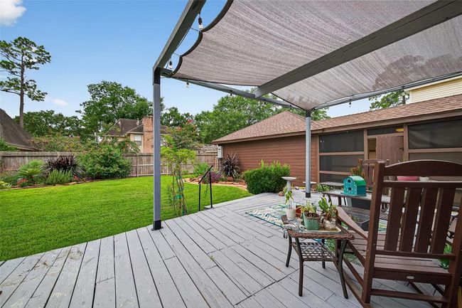 Step out onto a spacious raised deck, where you can overlook lush landscaping and enjoy breezy evenings or vibrant weekend gatherings under the open sky. | Image 43