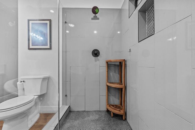 MAIN: Full bathroom featuring tile patterned floors, walk in shower, and toilet | Image 16