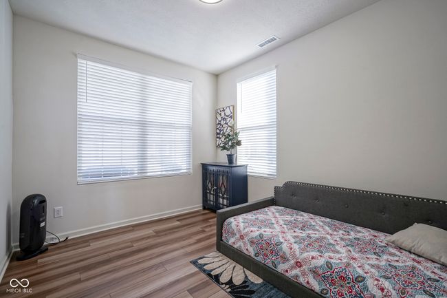 bedroom with baseboards, visible vents, and wood finished floors | Image 8