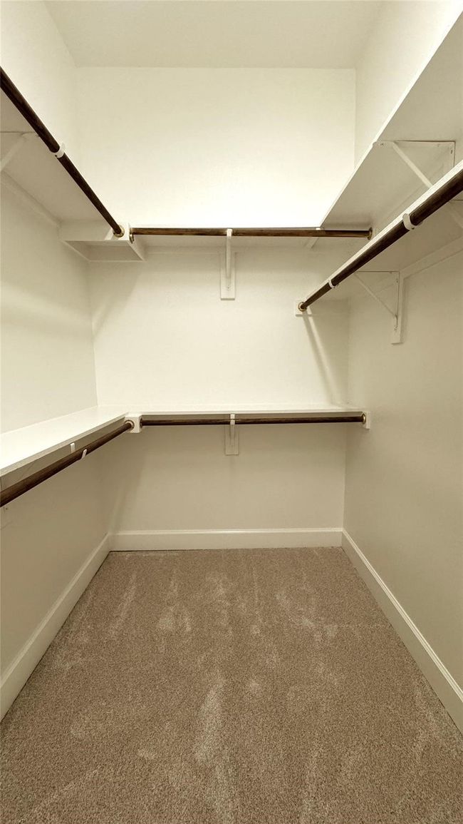 Walk in closet featuring light colored carpet | Image 8