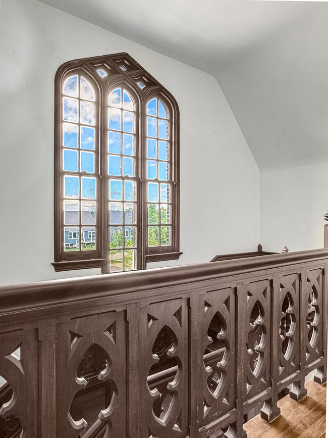 A dramatic arched window floods the upper hall wit | Image 30