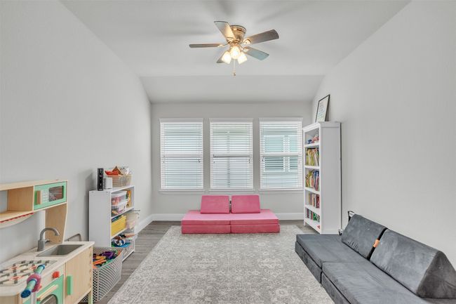 Rec room with wood finished floors, a ceiling fan, and vaulted ceiling | Image 20