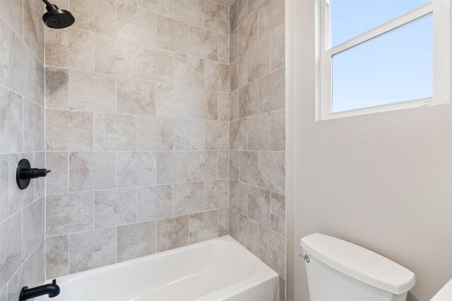 Second Bathroom featuring toilet and tiled shower / bath | Image 26