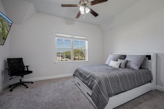 Bedroom featuring lofted ceiling, carpet flooring, baseboards, and a ceiling fan | Image 30