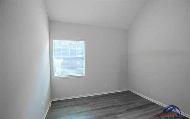 4th bedroom - This room features a minimalist design with neutral walls and laminate wood flooring. A window provides natural light, creating a bright and inviting space. | Image 40