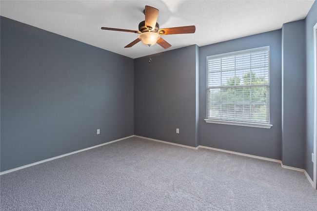 Carpeted spare room featuring a ceiling fan and baseboards | Image 36