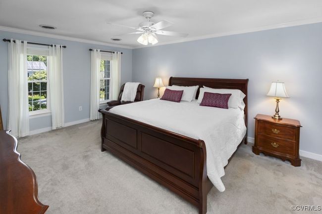 Bedroom featuring light colored carpet, baseboards, ornamental molding, and a ceiling fan | Image 24